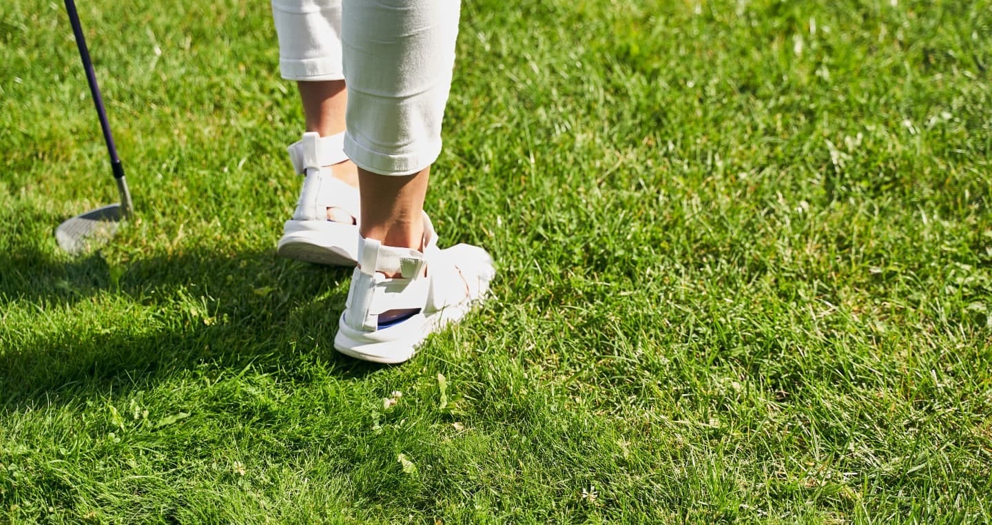 osoba grająca w golfa na zielonej murawie