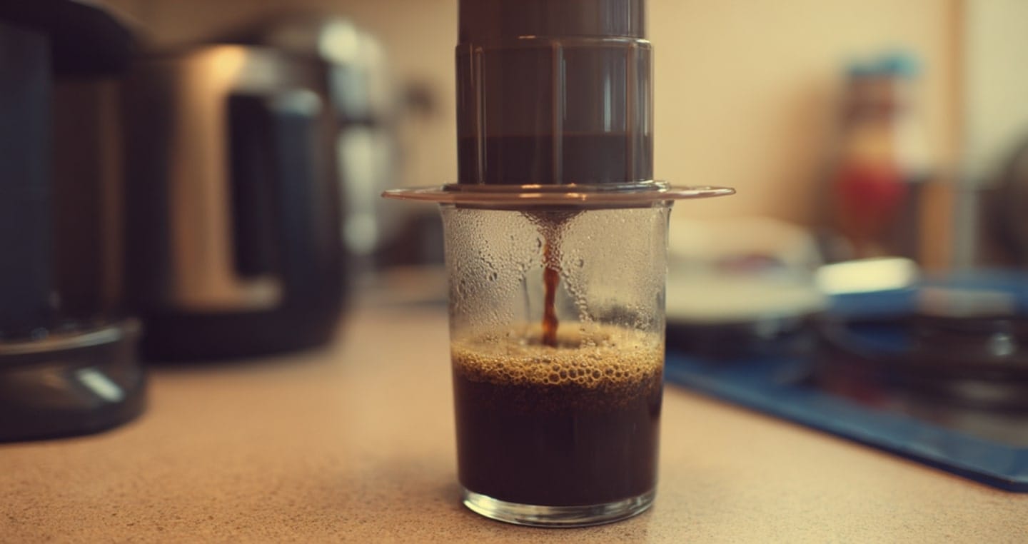 proces robienia kawy z aeropressu na drewnianym stole