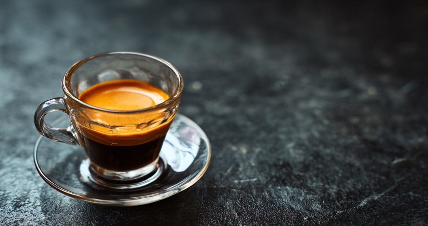Kawa ristretto w przeźroczystej małej filiżance na kamiennym stole