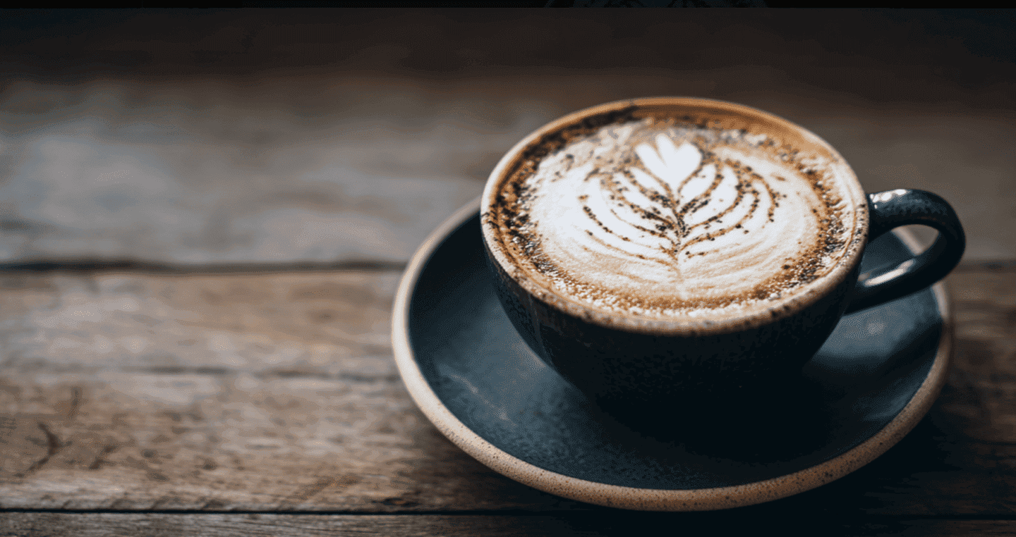 Ciemna filiżanka kawy rozpuszczalnej na drewnianym stole.