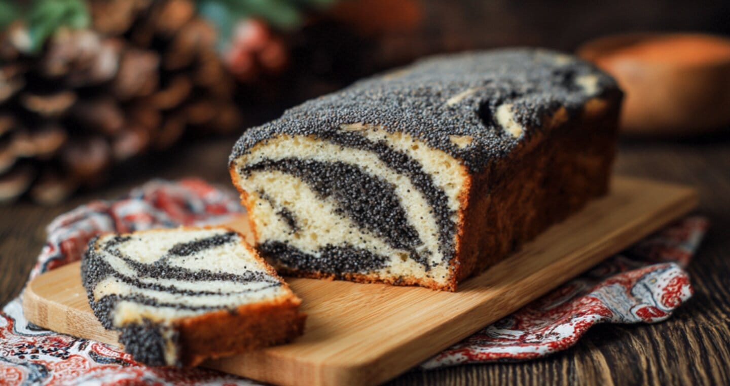 Makowiec z wyraźnym spiralnym wzorem nadzienia, pokrojony na plastry na desce.