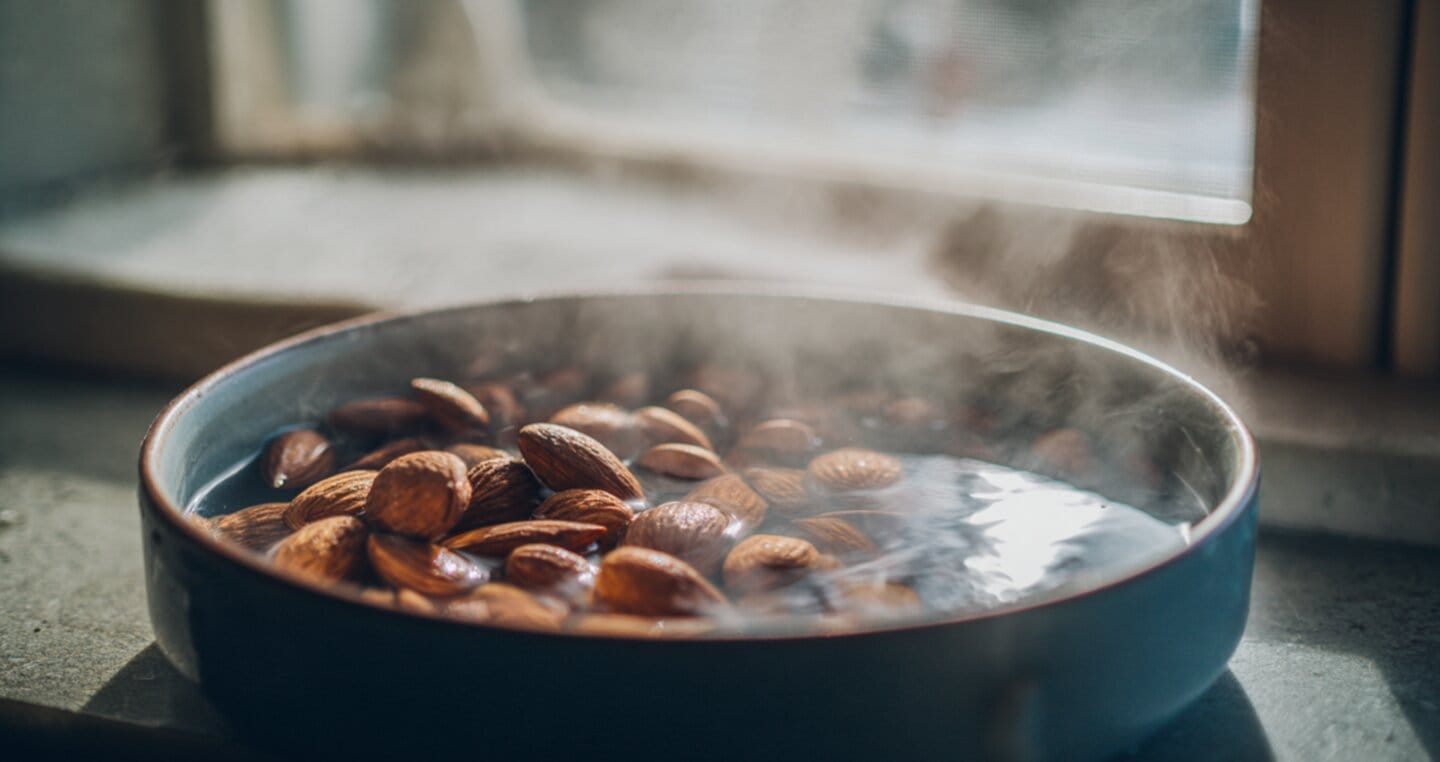 Migdały parzone w gorącej wodzie w misce na parapecie.