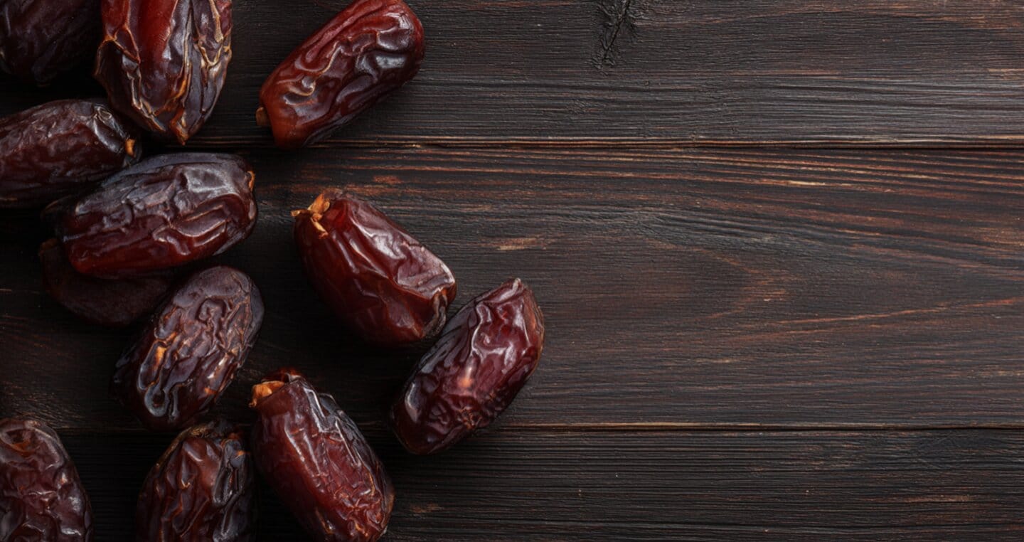 Suszone daktyle na ciemnym, drewnianym tle.