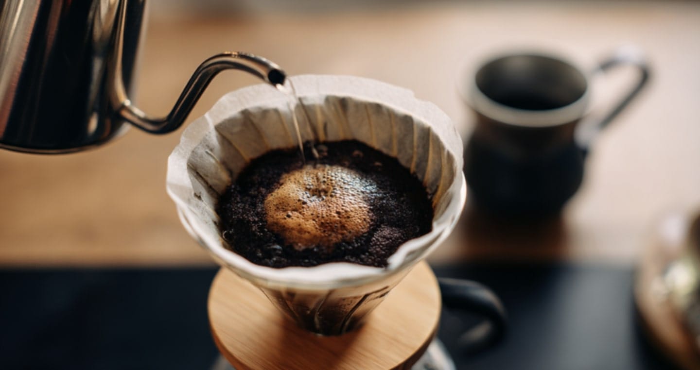Zapaarzanie kawy metodą dripa, gorąca woda nalewana na zmielone ziarna w filtrze.